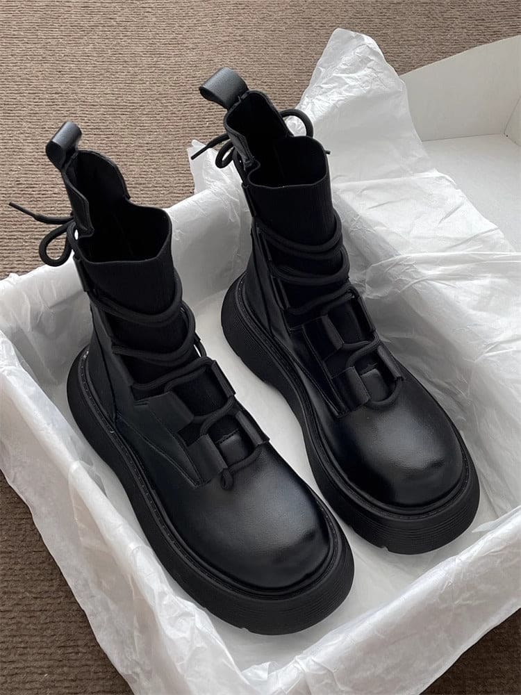 Pair of high-top lace-up platform boots with chunky soles in a neutral tone, displayed on white tissue paper in an open box._2