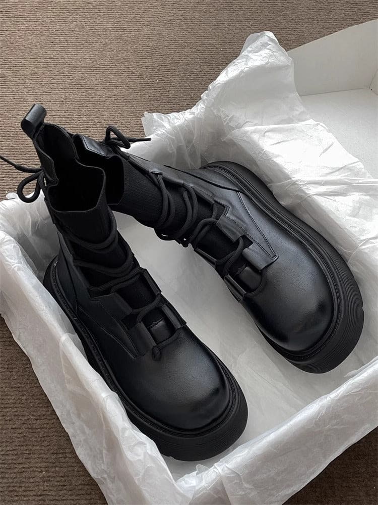 Pair of high-top lace-up platform boots with chunky soles in a neutral tone, displayed on white tissue paper in an open box._5
