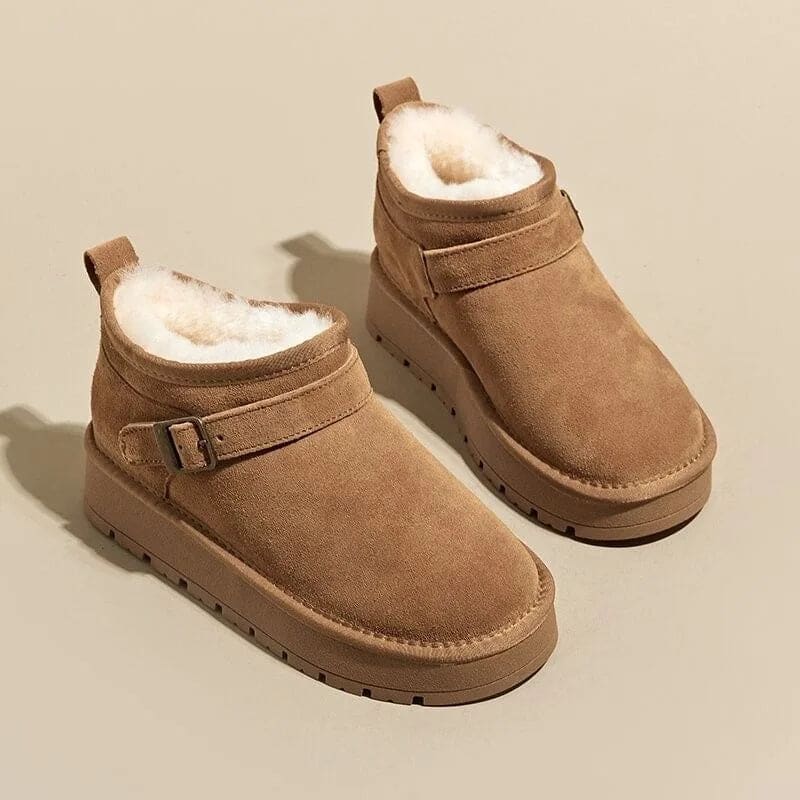 Close-up of a person wearing tan ankle boots with plush lining, buckle detail, and platform sole, paired with gray joggers and neutral socks._11
