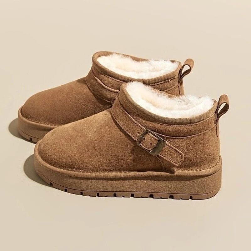 Close-up of a person wearing tan ankle boots with plush lining, buckle detail, and platform sole, paired with gray joggers and neutral socks._13
