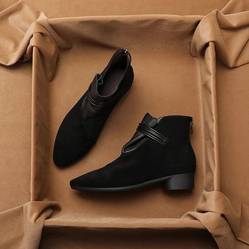 A side view of a pointed toe ankle boot with a decorative strap detail and low block heel._13