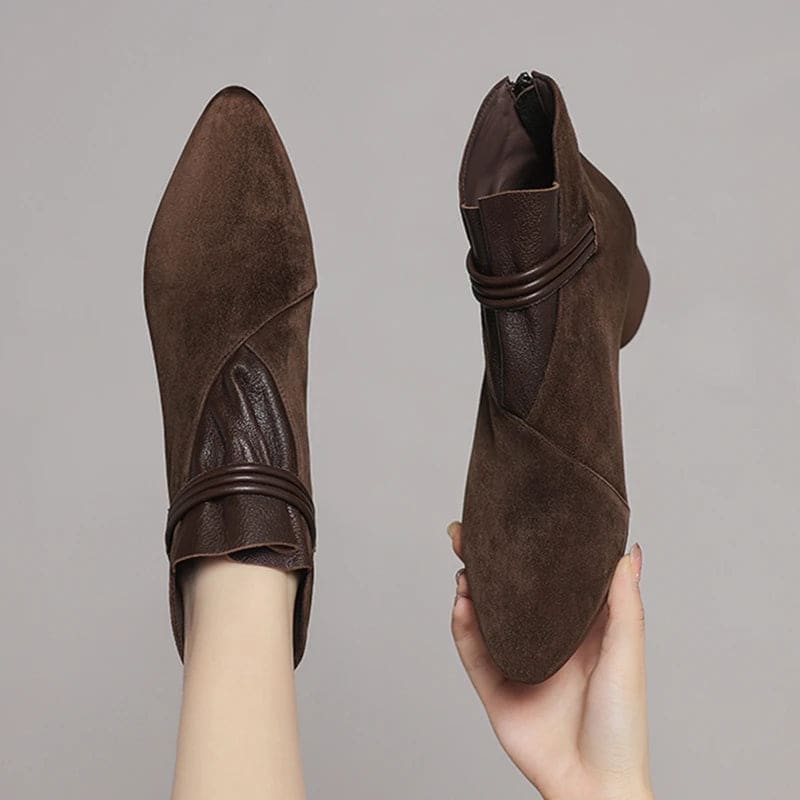 A side view of a pointed toe ankle boot with a decorative strap detail and low block heel._20