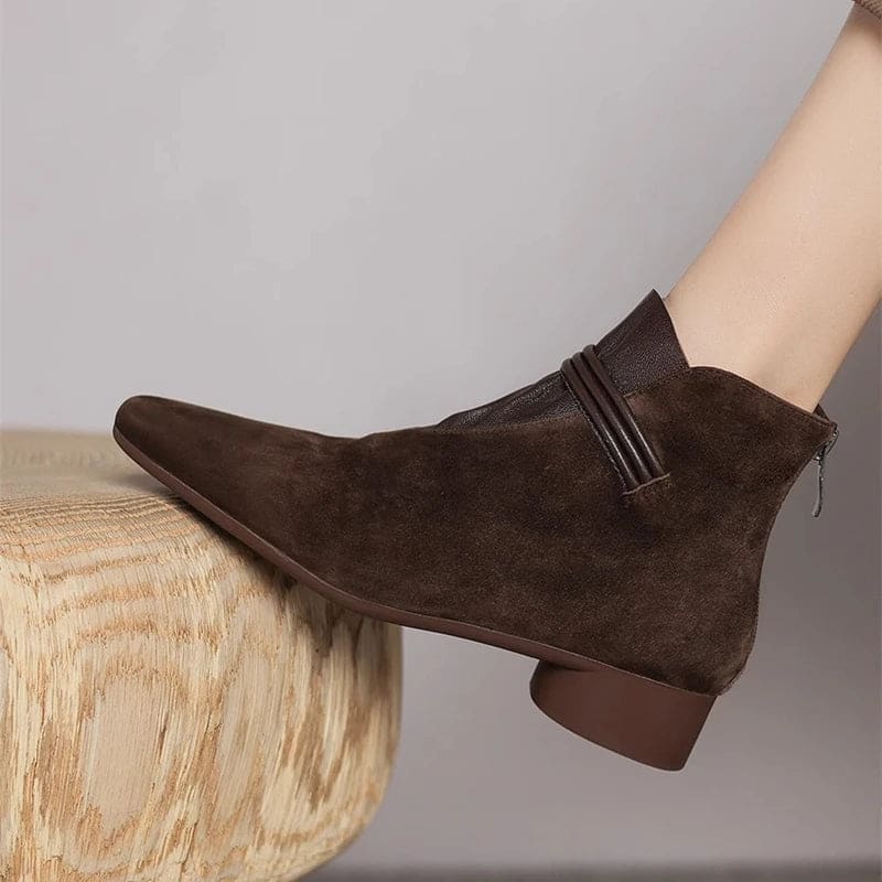 A side view of a pointed toe ankle boot with a decorative strap detail and low block heel._21