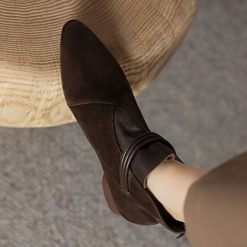 A side view of a pointed toe ankle boot with a decorative strap detail and low block heel._22
