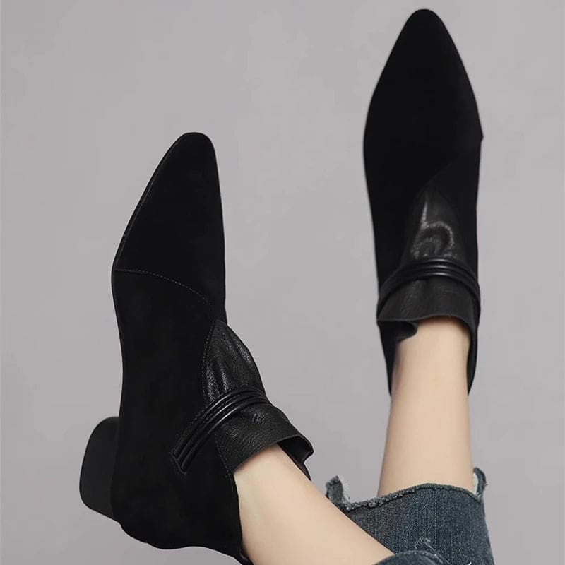A side view of a pointed toe ankle boot with a decorative strap detail and low block heel._25