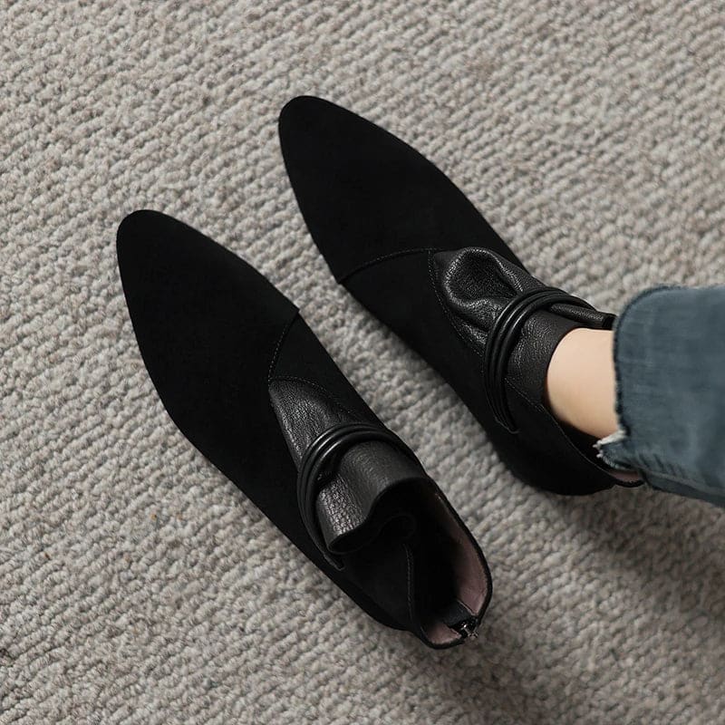 A side view of a pointed toe ankle boot with a decorative strap detail and low block heel._26