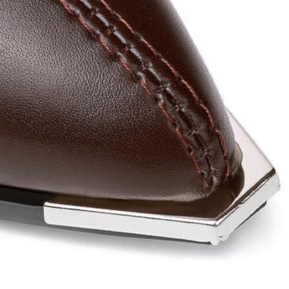 Pair of pointed toe chelsea boots with chrome tip detail and chunky block heel displayed on newspaper background_8