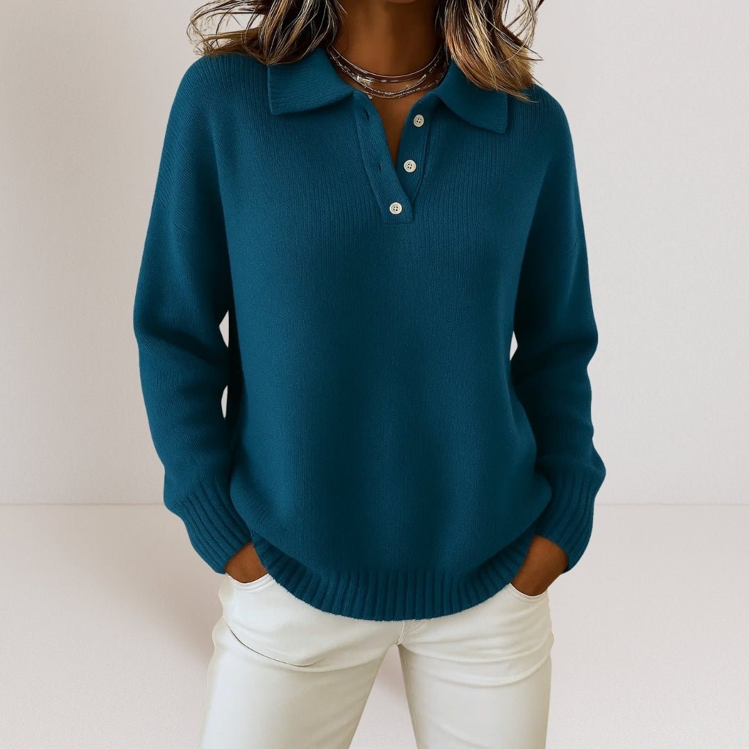 Deep teal polo collar sweater featuring a three-button placket and ribbed trim, paired with white pants.