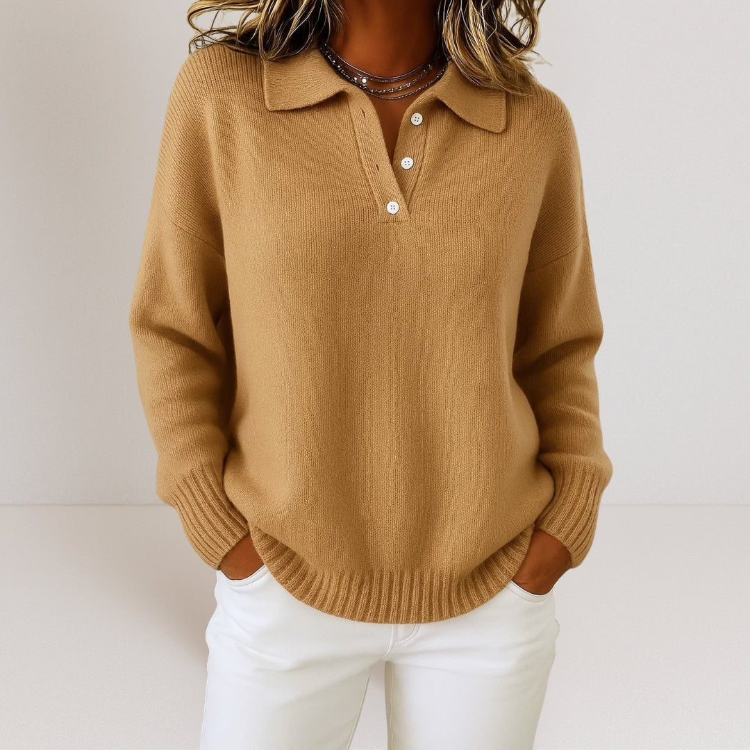 Camel polo collar sweater with a button placket and softly relaxed fit, shown with white pants.