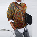 Woman wearing a long-sleeved button-front jacket with a colourful vintage floral print over a white shirt and grey trousers, holding a black backpack._0
