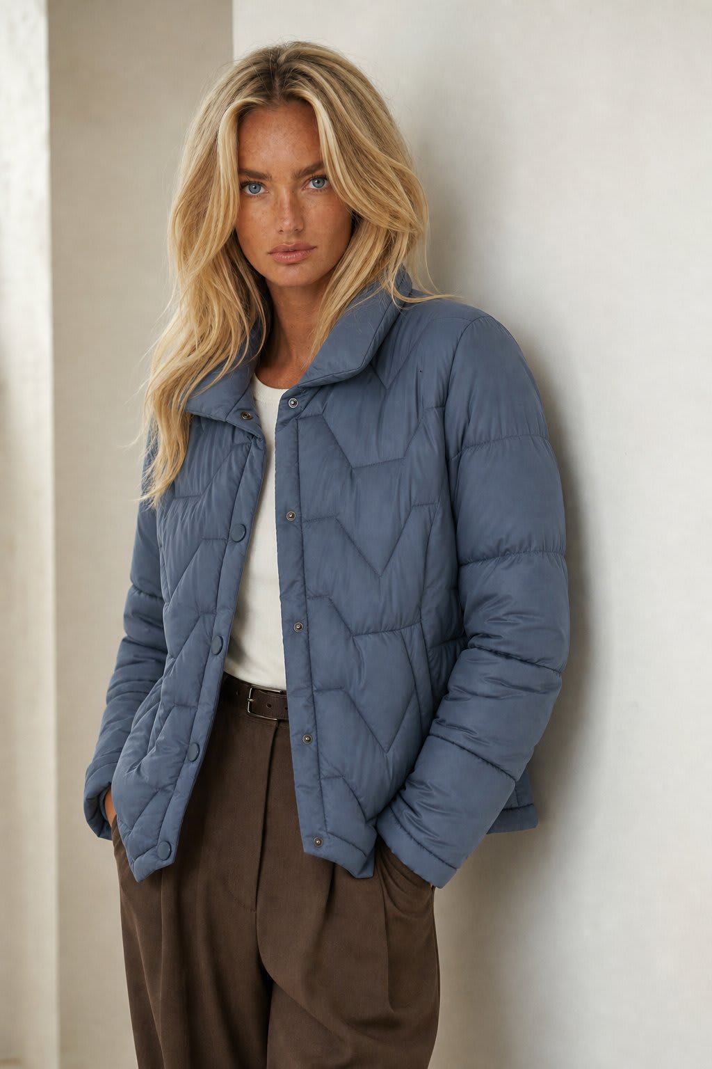 Woman wearing a quilted jacket with chevron stitching and snap button front closure._1
