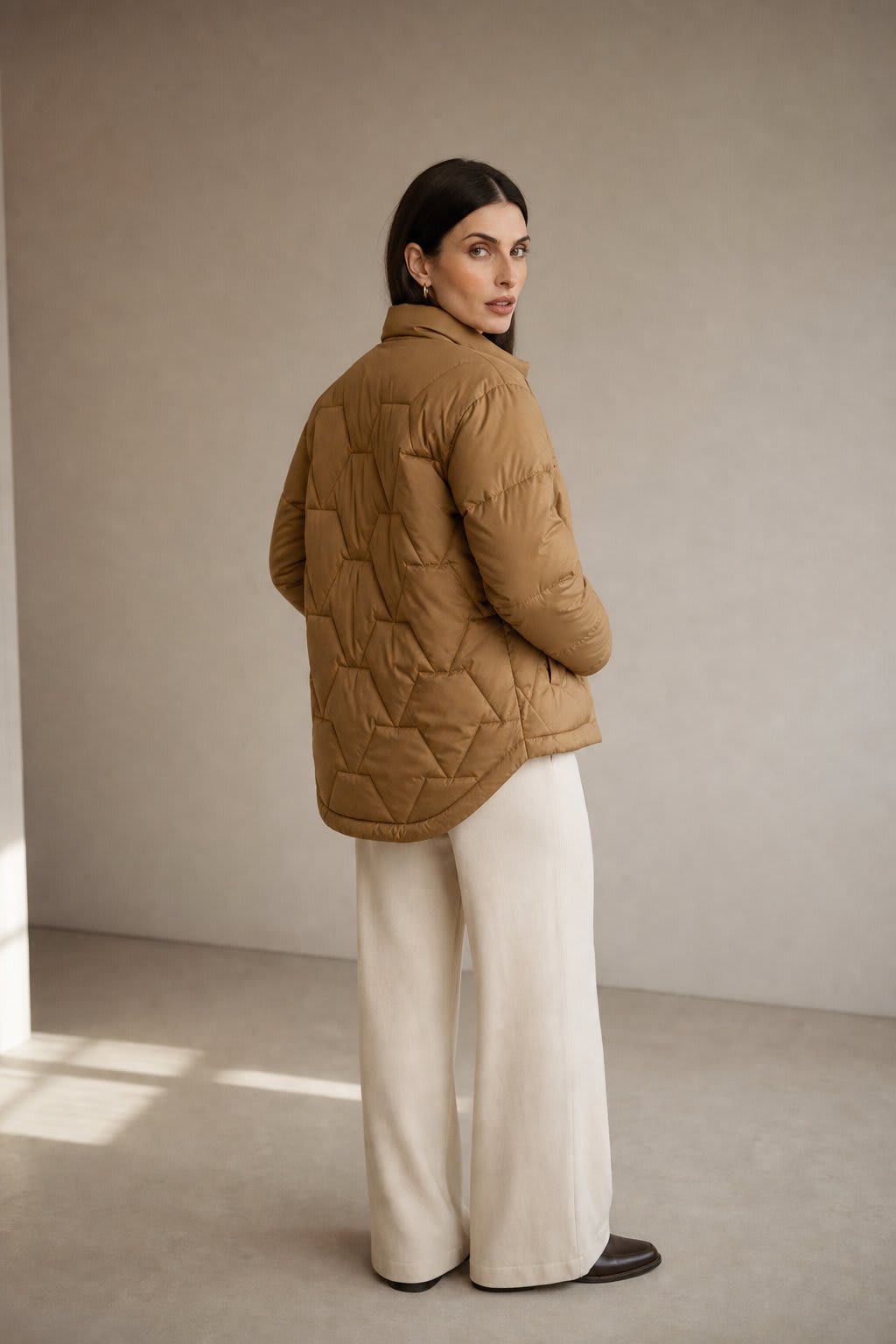 Woman wearing a quilted jacket with chevron stitching and snap button front closure._2
