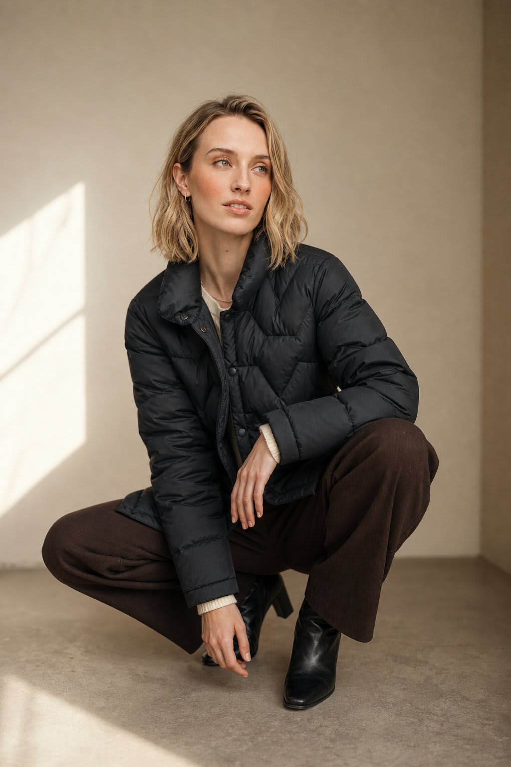Woman wearing a quilted jacket with chevron stitching and snap button front closure._6