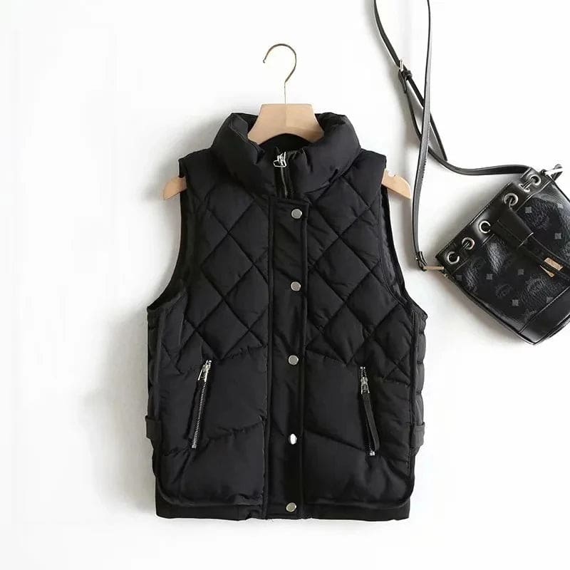 Model wearing a cream quilted vest with stand collar over a neutral sweater and brown trousers._22