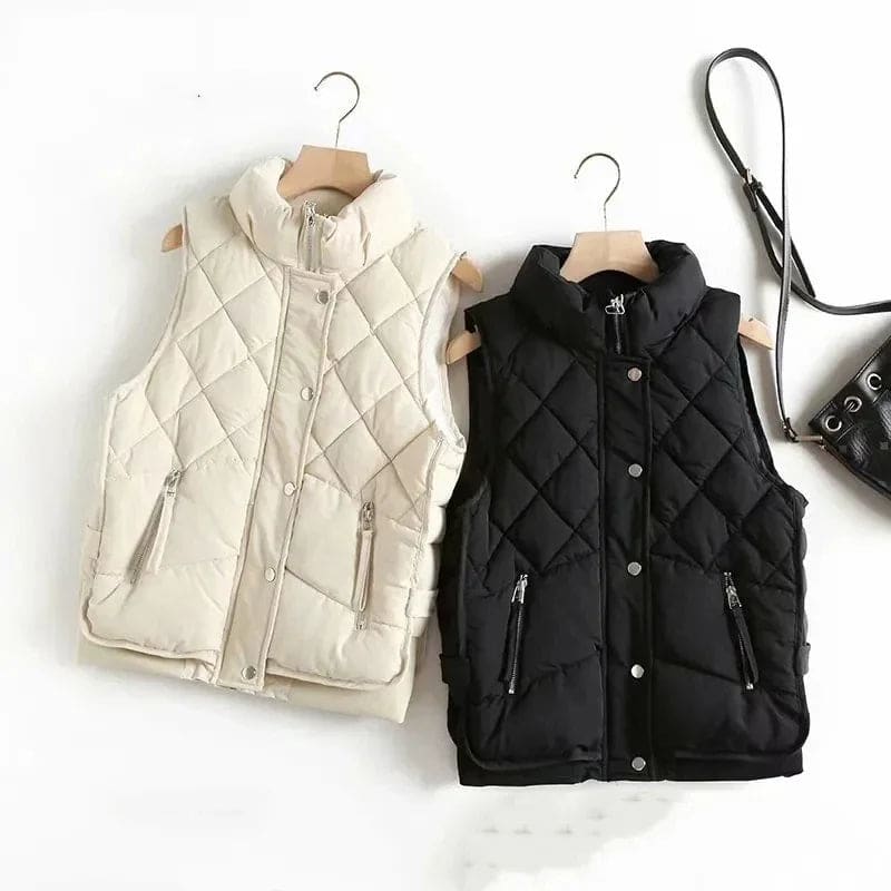 Model wearing a cream quilted vest with stand collar over a neutral sweater and brown trousers._6