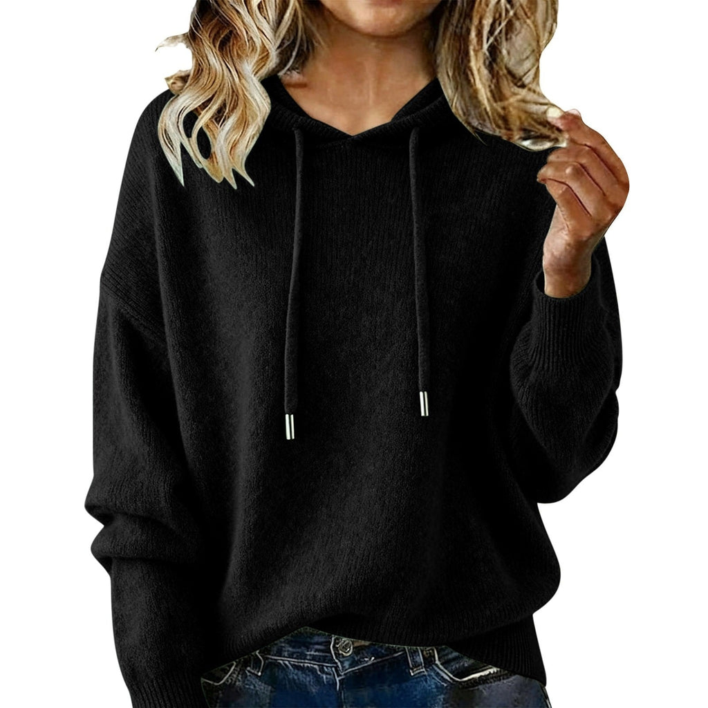Black relaxed hoodie featuring a drawstring hood, oversized sleeves, and a casual jeans pairing.