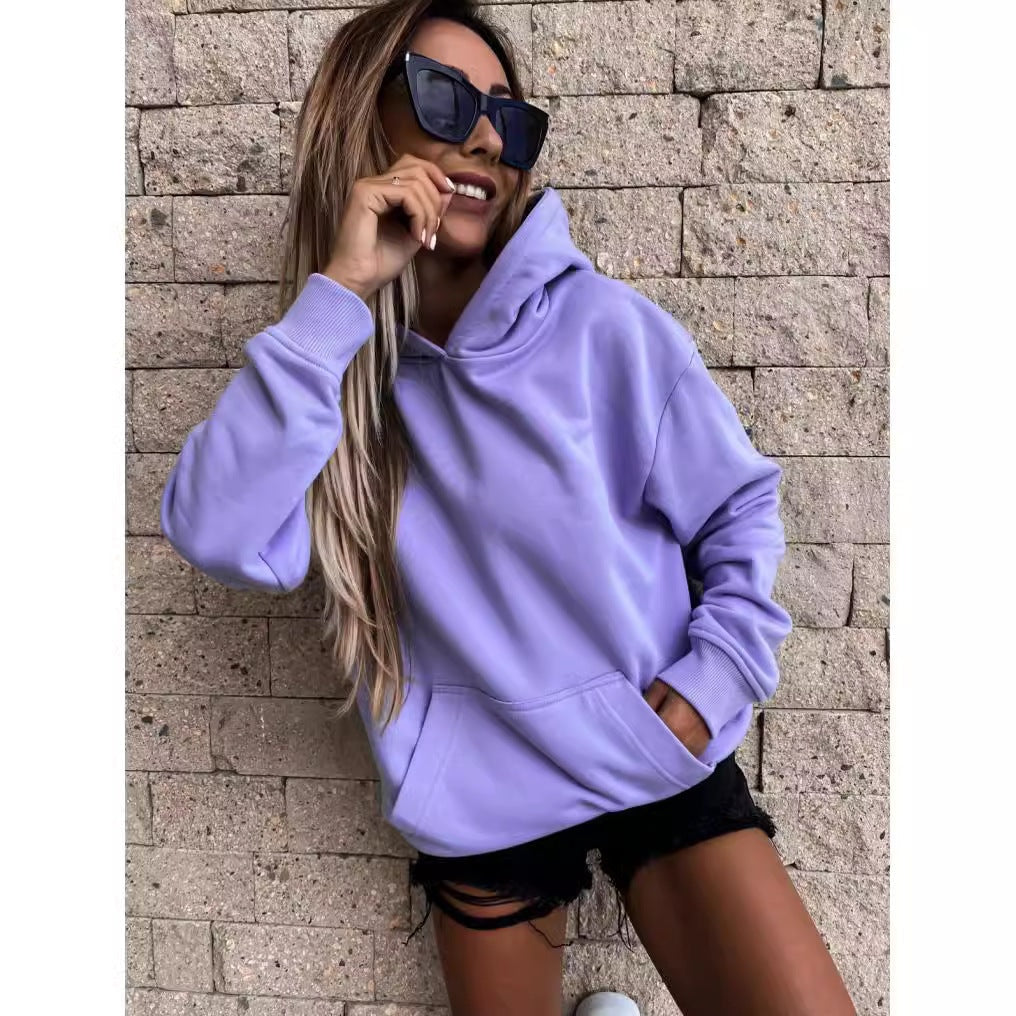 Lavender relaxed-fit hoodie with ribbed cuffs and a front pocket, modeled with one hand tucked inside.