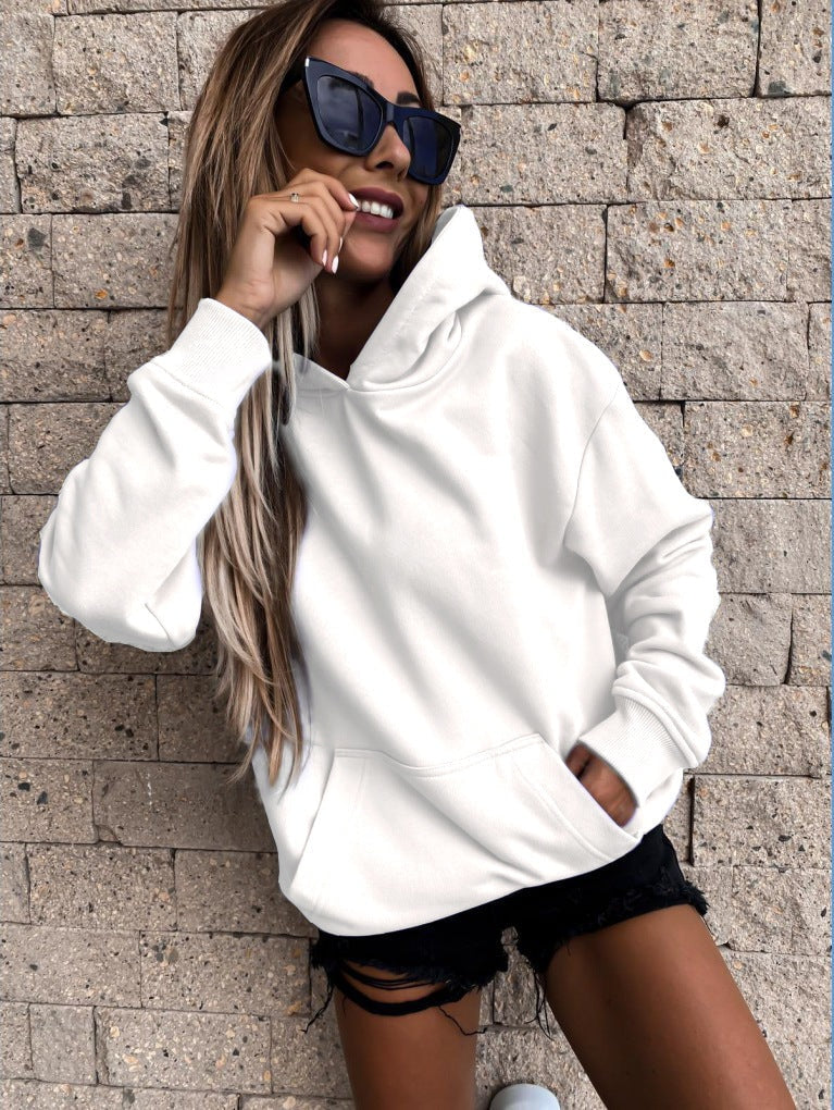 Bright white relaxed-fit hoodie shown straight on, with long sleeves, a roomy hood, and hands resting in the front pocket.