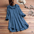 Blue relaxed longline tunic hoodie with a softly draped hood, long sleeves, button accents at the side, and a gently uneven hem.