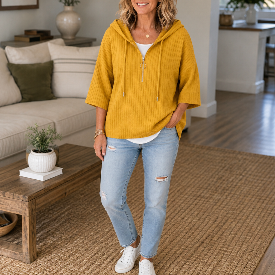 Mustard yellow ribbed half-zip hooded top worn with light jeans and white sneakers.