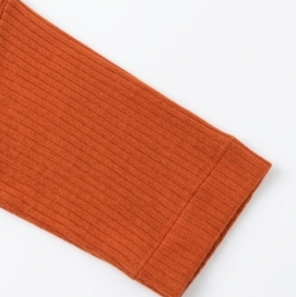 Close-up of the orange top’s elbow-length sleeve and finished cuff.