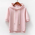 Pink short sleeve hooded top with white drawstring, cuffed sleeves and side slits on a wooden hanger._0
