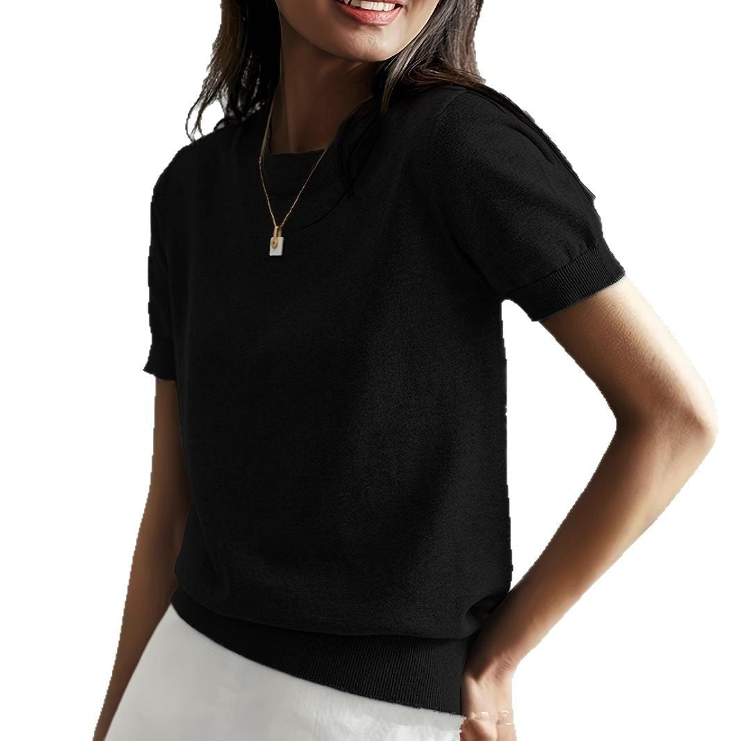 Black short sleeve crew neck sweater with ribbed cuffs and hem, styled with light-colored bottoms.