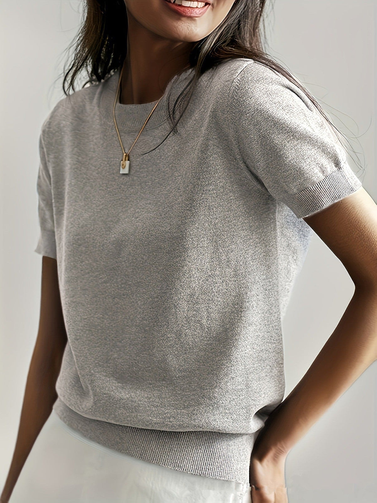 Light gray short sleeve crew neck sweater with a minimal front and ribbed trim around the sleeves and hem.