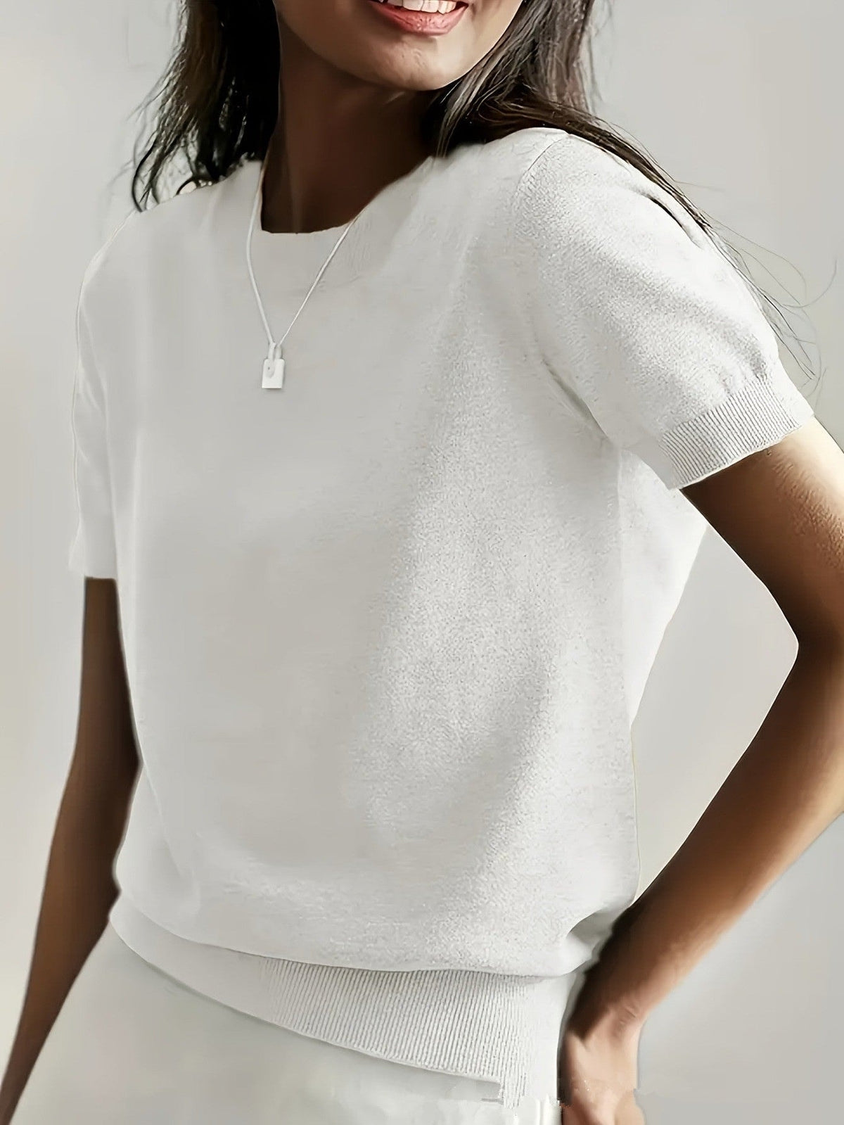 White short sleeve crew neck sweater shown from the front, with matching ribbed cuffs and waistband.