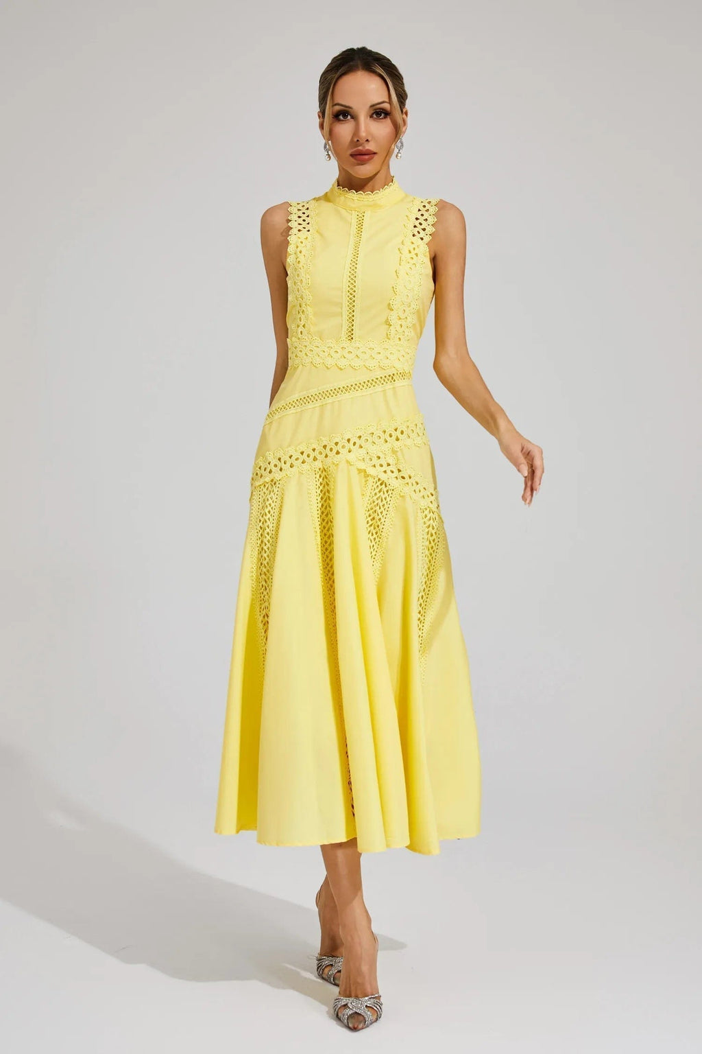 Woman wearing a yellow sleeveless midi dress with lace paneling, crochet trim, and a flared hem._0