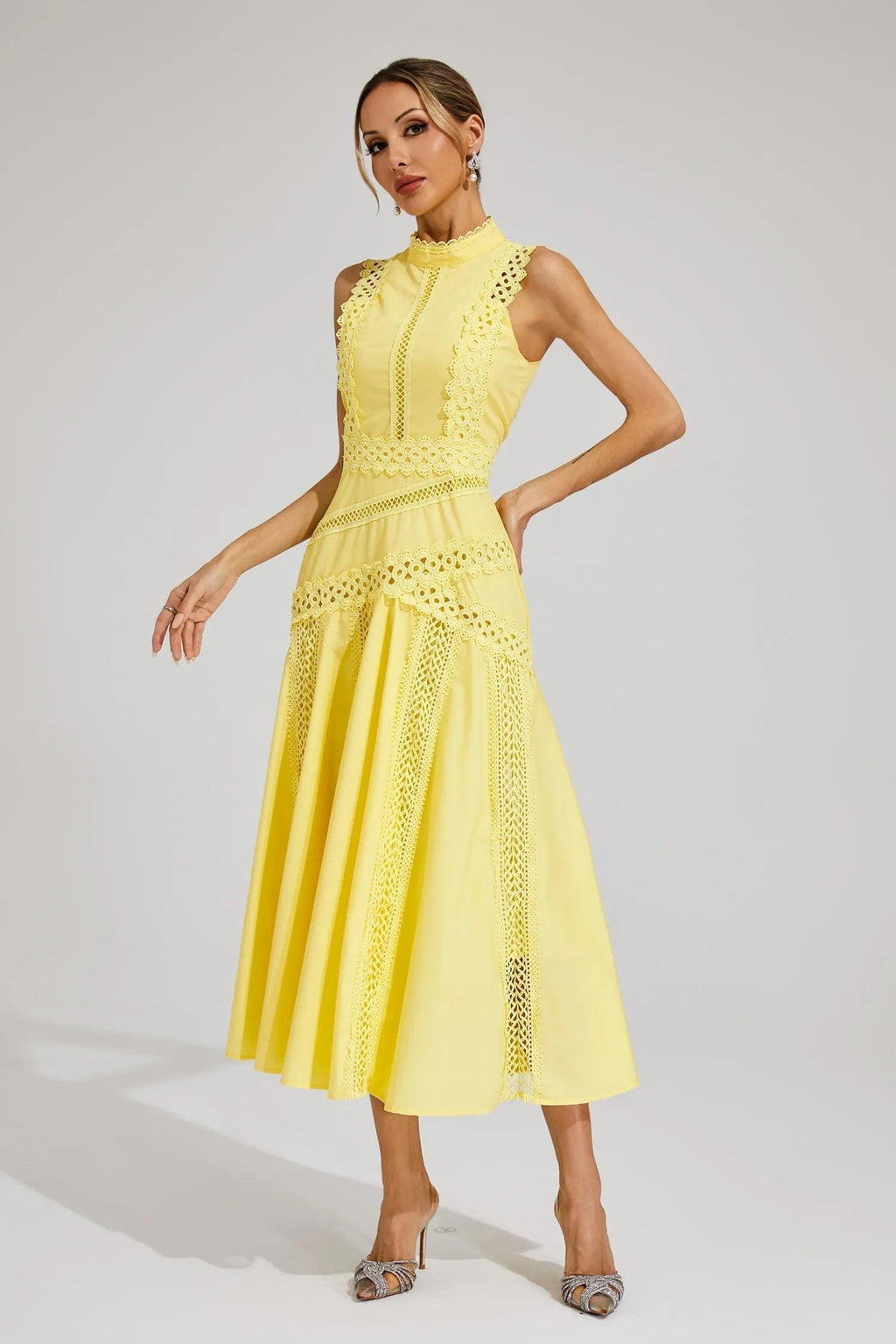 Woman wearing a yellow sleeveless midi dress with lace paneling, crochet trim, and a flared hem._1