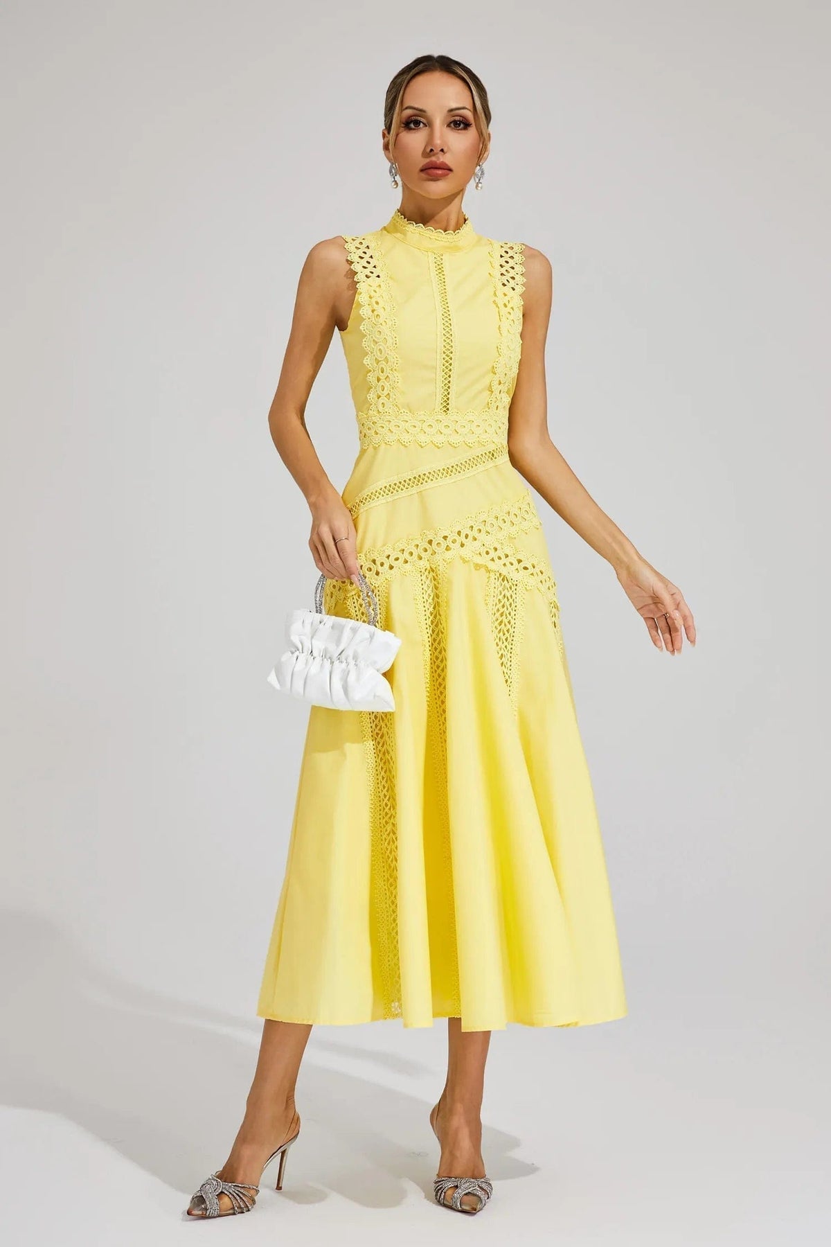 Woman wearing a yellow sleeveless midi dress with lace paneling, crochet trim, and a flared hem._2