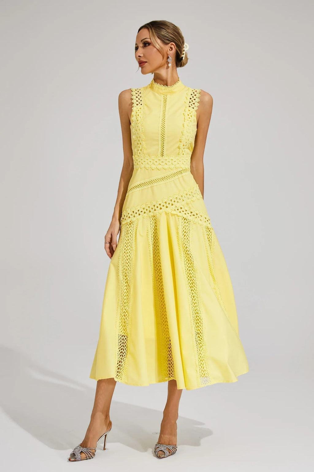 Woman wearing a yellow sleeveless midi dress with lace paneling, crochet trim, and a flared hem._3