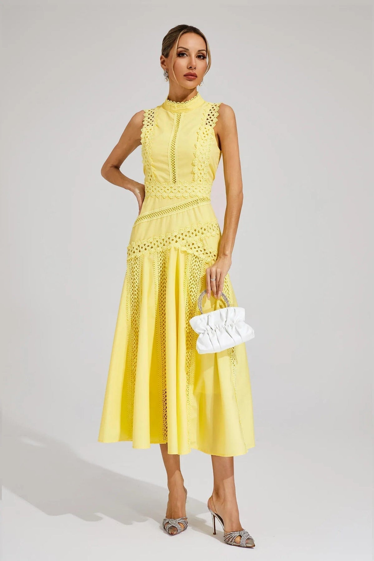 Woman wearing a yellow sleeveless midi dress with lace paneling, crochet trim, and a flared hem._4