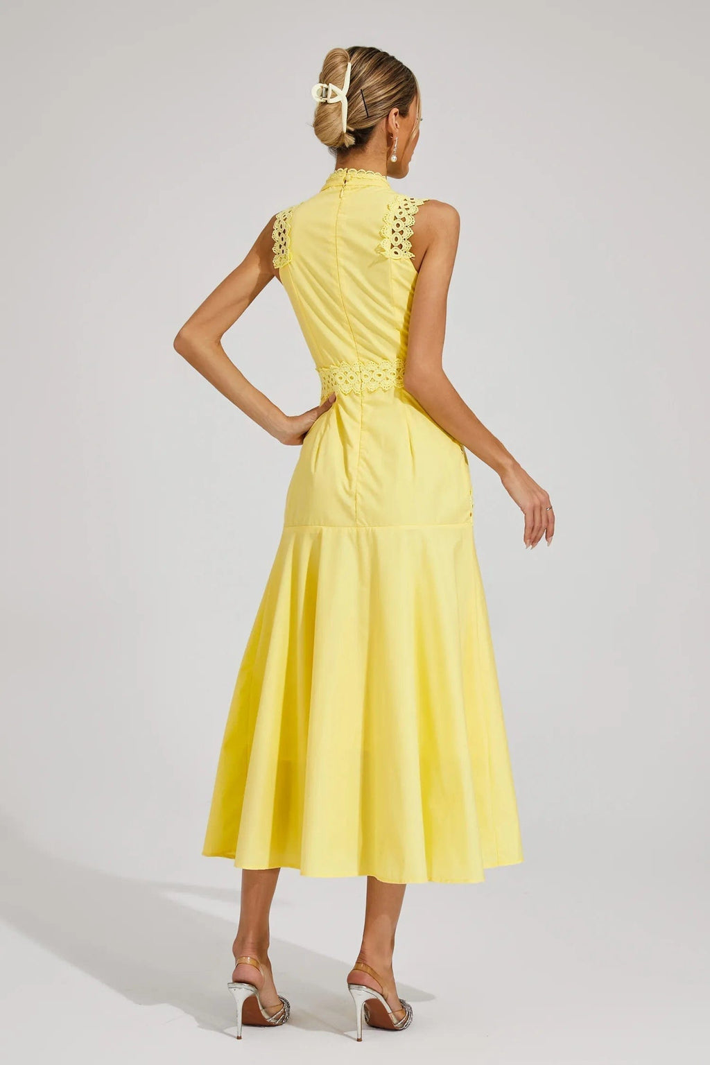 Woman wearing a yellow sleeveless midi dress with lace paneling, crochet trim, and a flared hem._5