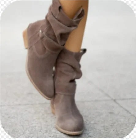 Taupe slouchy mid-calf boots shown from the front in a crossed-leg pose, with rounded pointed toes and low heels.