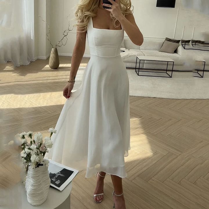 Woman wearing an elegant square neck midi dress in a bright modern interior_0