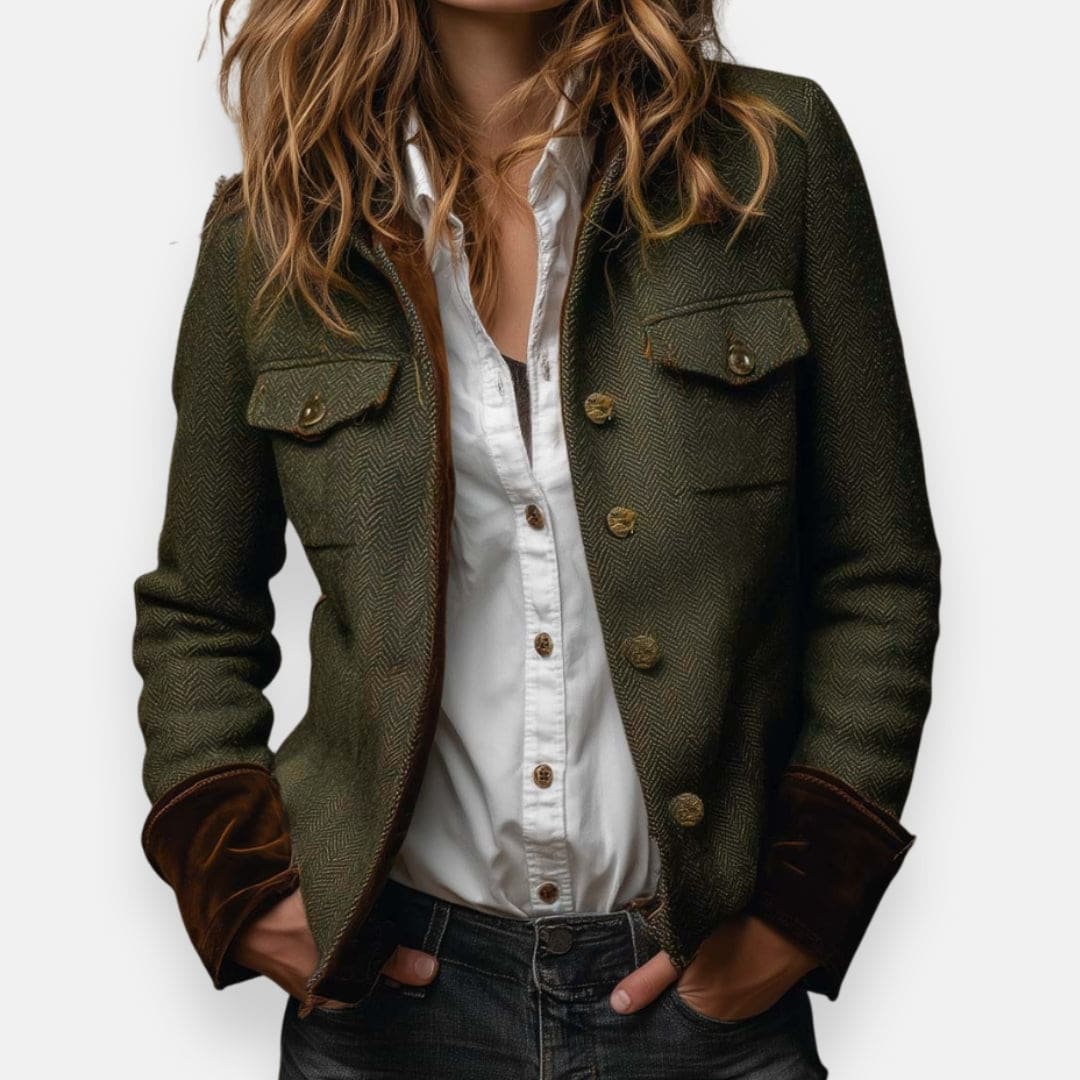 Woman wearing a structured herringbone jacket with contrast brown cuffs, chest pockets, and button-front closure, layered over a white shirt and jeans._0