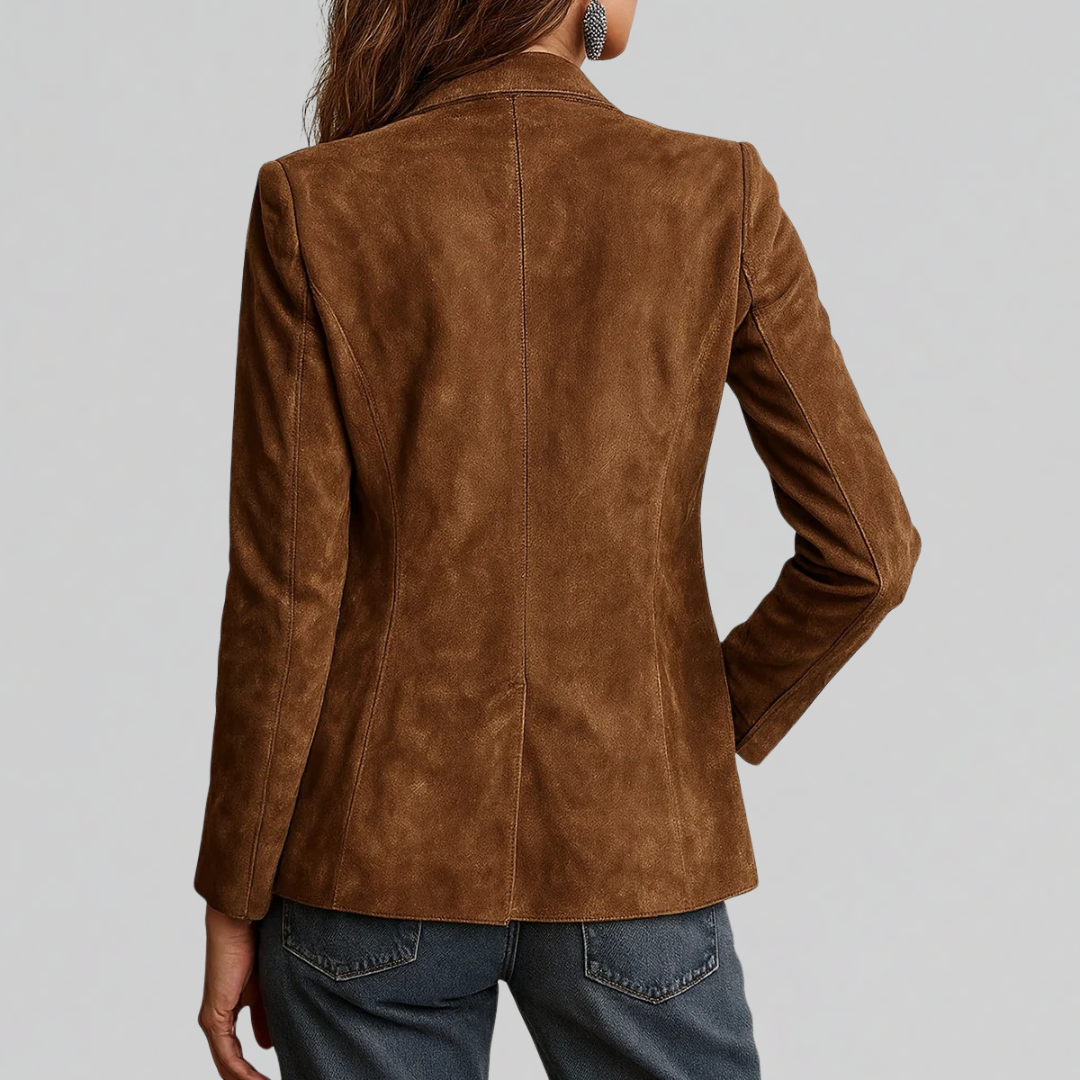 Woman wearing a structured brown blazer layered over a white button-down blouse with jeans and layered necklaces._1