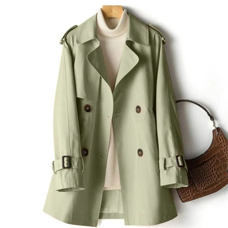 A double breasted trench coat with wide lapels, shoulder epaulets, and buckle cuff tabs is shown on a hanger._0