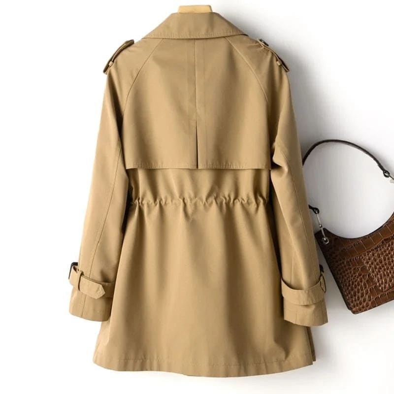 A double breasted trench coat with wide lapels, shoulder epaulets, and buckle cuff tabs is shown on a hanger._5