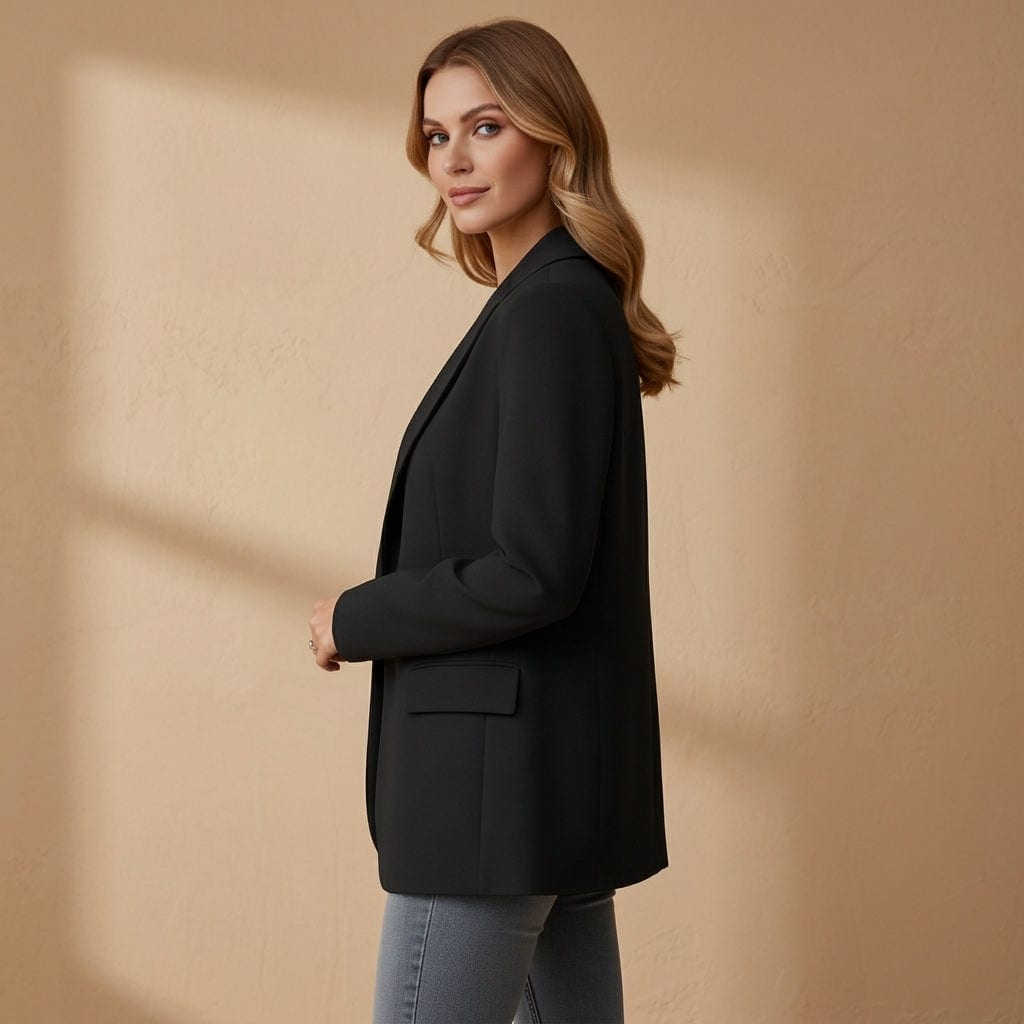 Woman wearing a black tailored blazer with notched lapel and front pockets over a white top and jeans._7