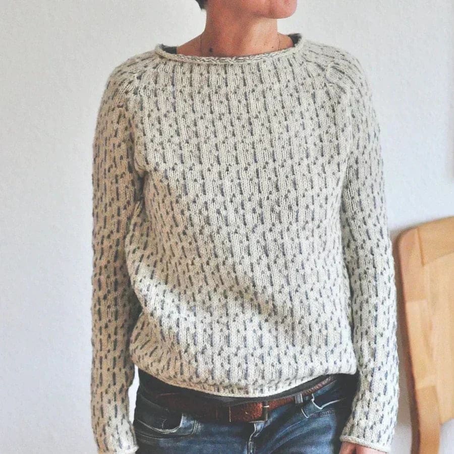 Woman wearing a relaxed fit crew neck sweater with textured knit pattern and ribbed detailing in a neutral tone._1