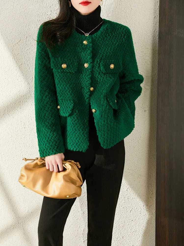 Woman wearing a textured short jacket with gold buttons in a tailored silhouette, viewed from behind._16