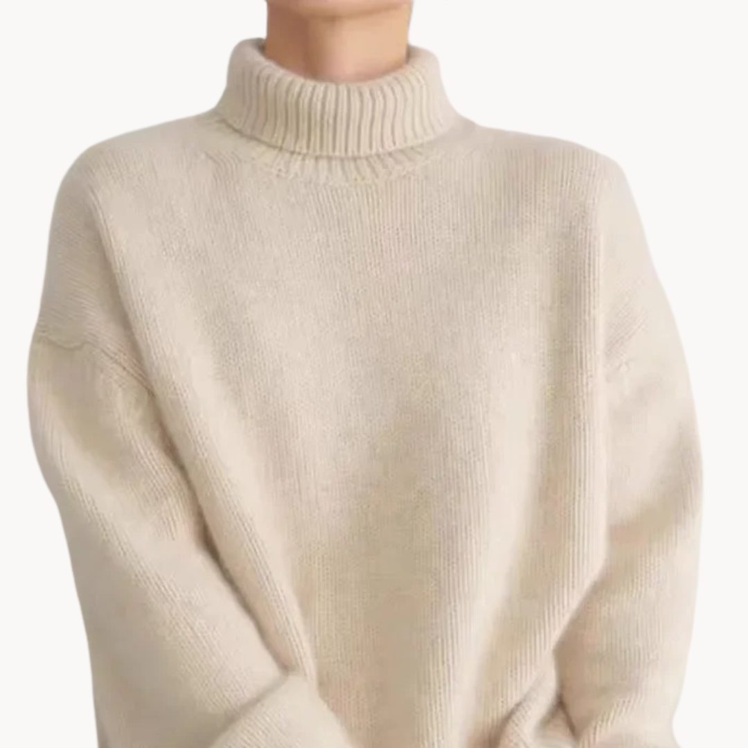 Woman wearing a cream oversized turtleneck sweater with ribbed detailing and relaxed fit, styled with a tan handbag._2