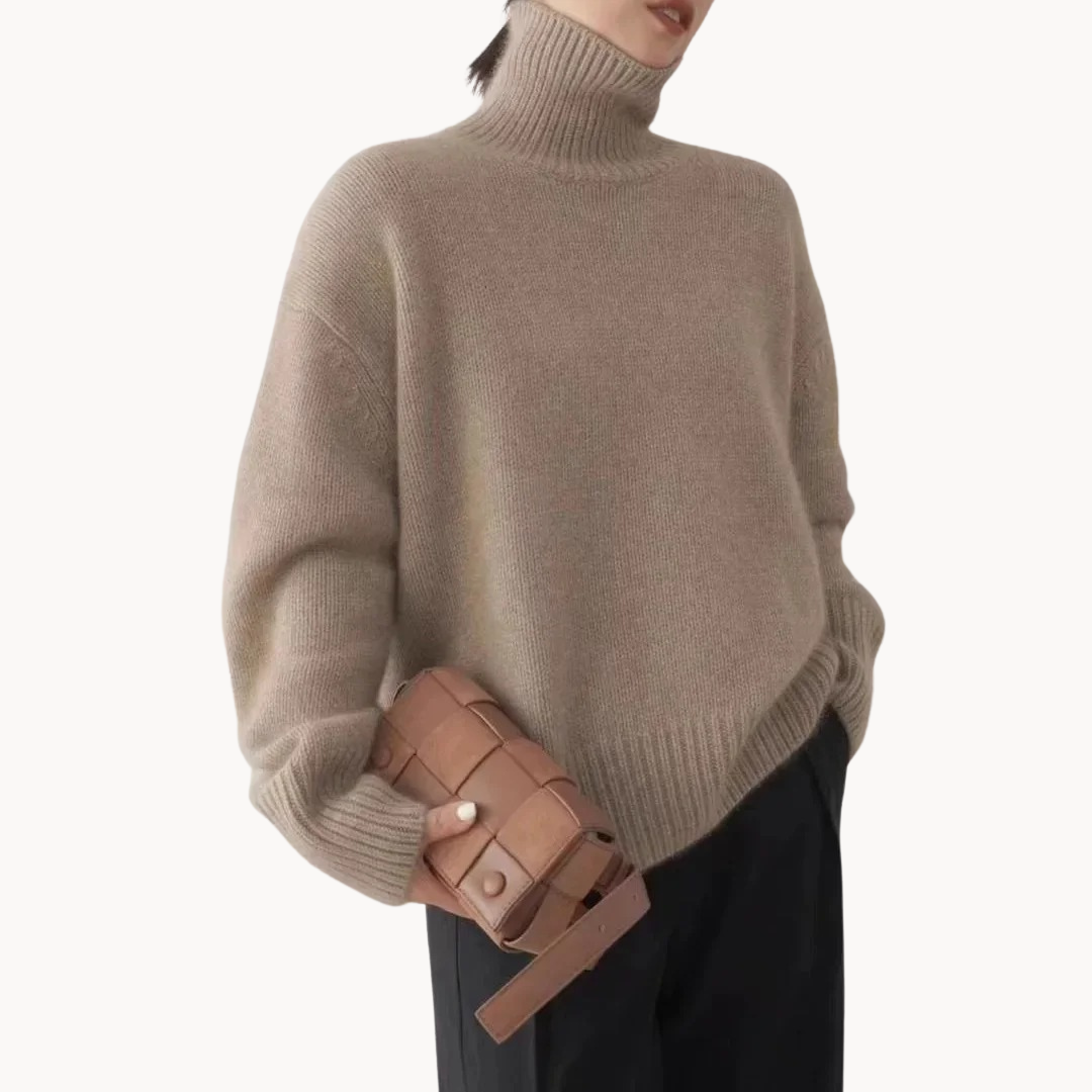 Woman wearing a cream oversized turtleneck sweater with ribbed detailing and relaxed fit, styled with a tan handbag._5