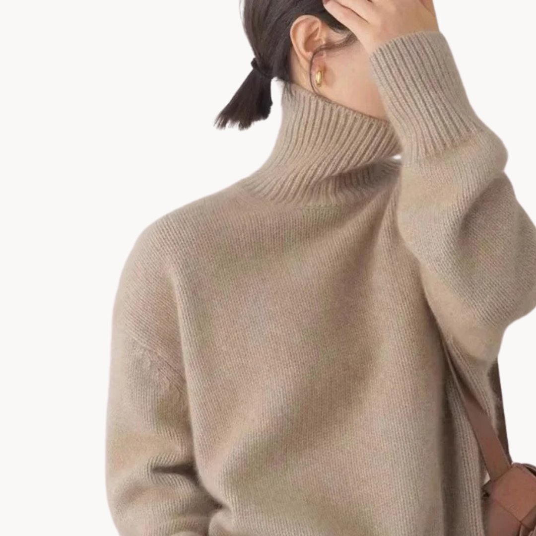 Woman wearing a cream oversized turtleneck sweater with ribbed detailing and relaxed fit, styled with a tan handbag._6