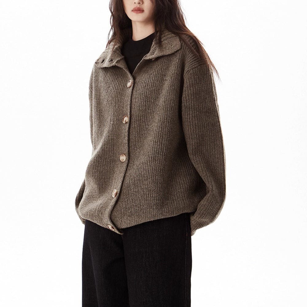 A model wears a relaxed button front cardigan with a foldover collar over a dark top and wide-leg pants._0