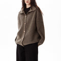 A model wears a relaxed button front cardigan with a foldover collar over a dark top and wide-leg pants._0