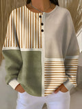 Woman wearing a waffle knit colorblock henley top with cream, sage green, and striped panels, featuring a three-button neckline and relaxed fit._0
